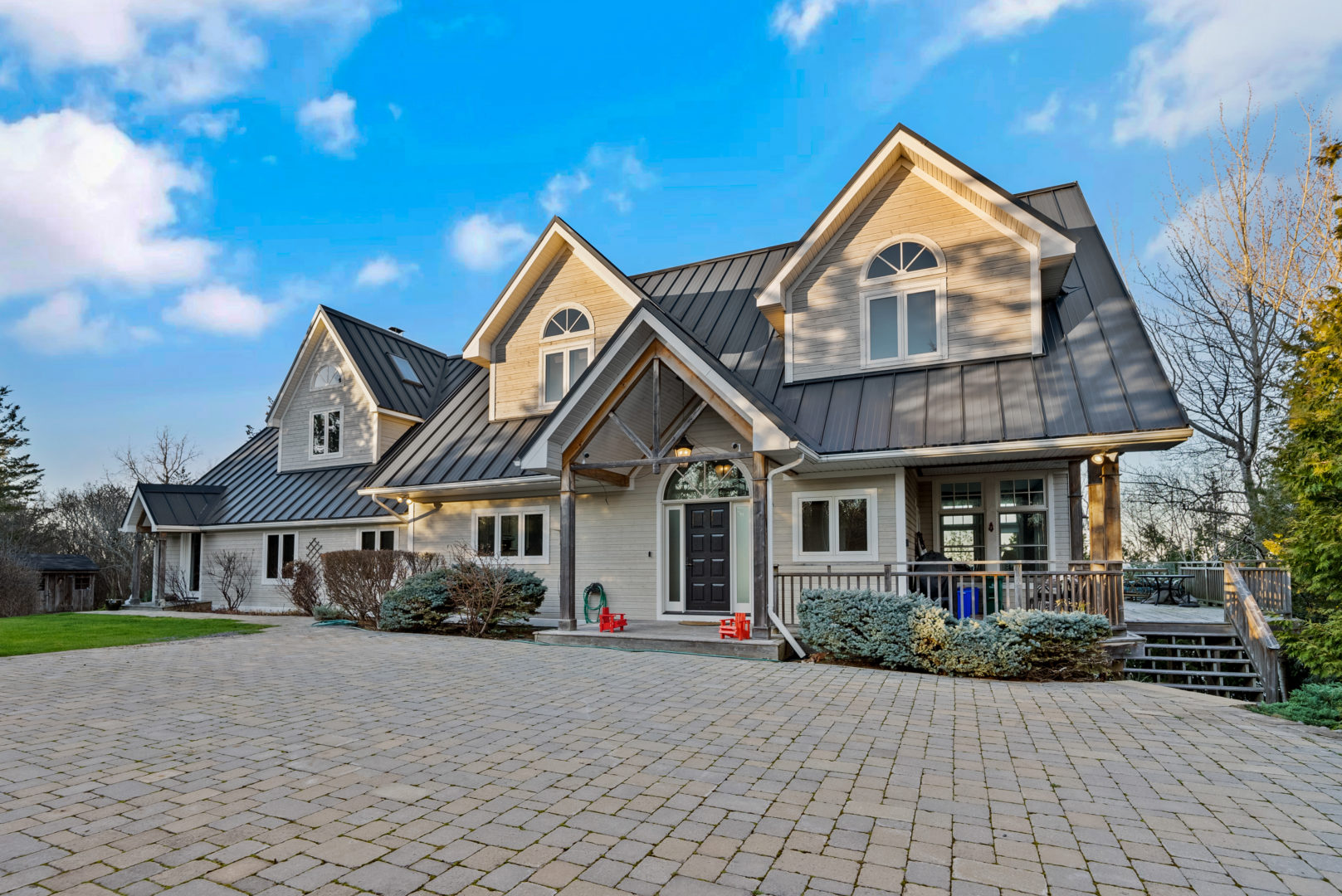 A large two-story house with lots of windows and a brick driveway.