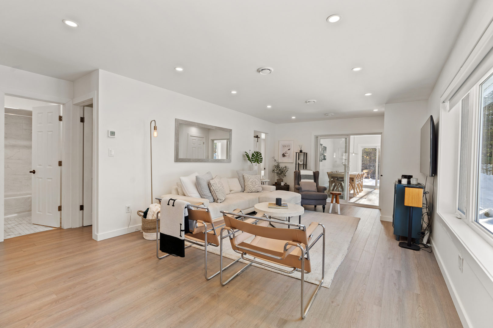 Inside a small cottage bungalow. A bright open-concept space leads into a living area.