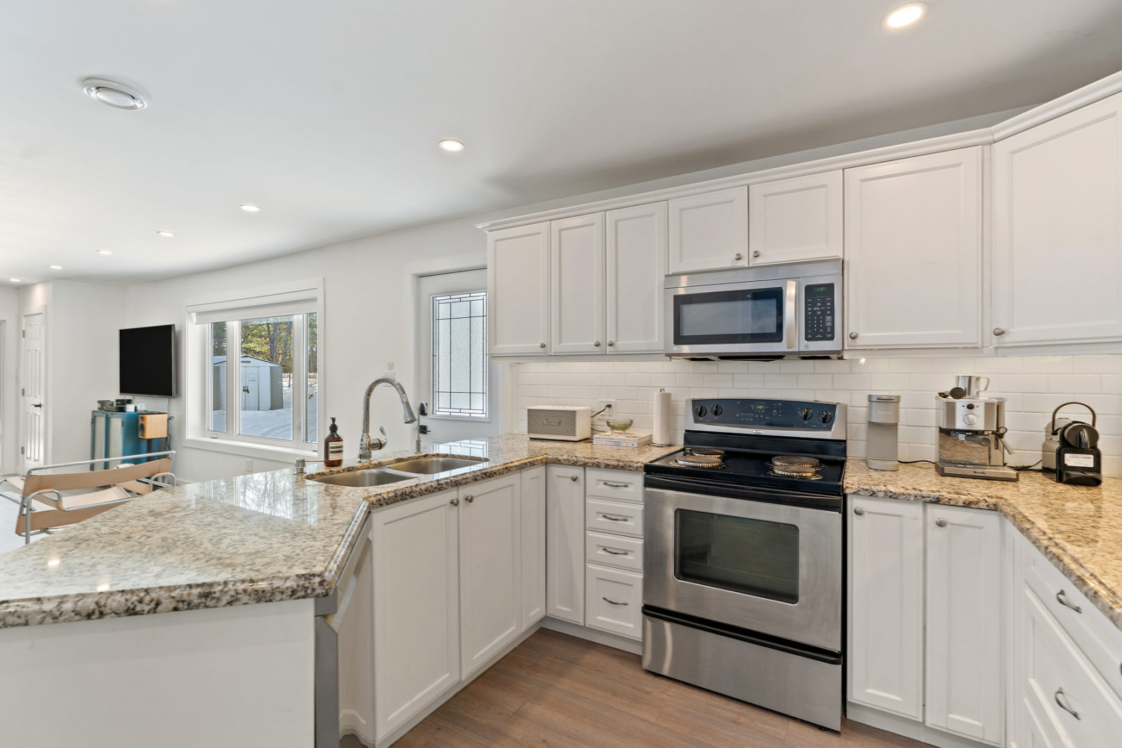 A bright kitchen with updated appliances and a large peninsula, offering lots of counter space.