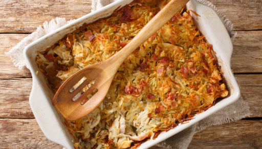 Canadian Rappie Pie, an Acadian classic comfort food dish made with grated potatoes and chicken closeup in a baking dish on the table. Horizontal top view from above