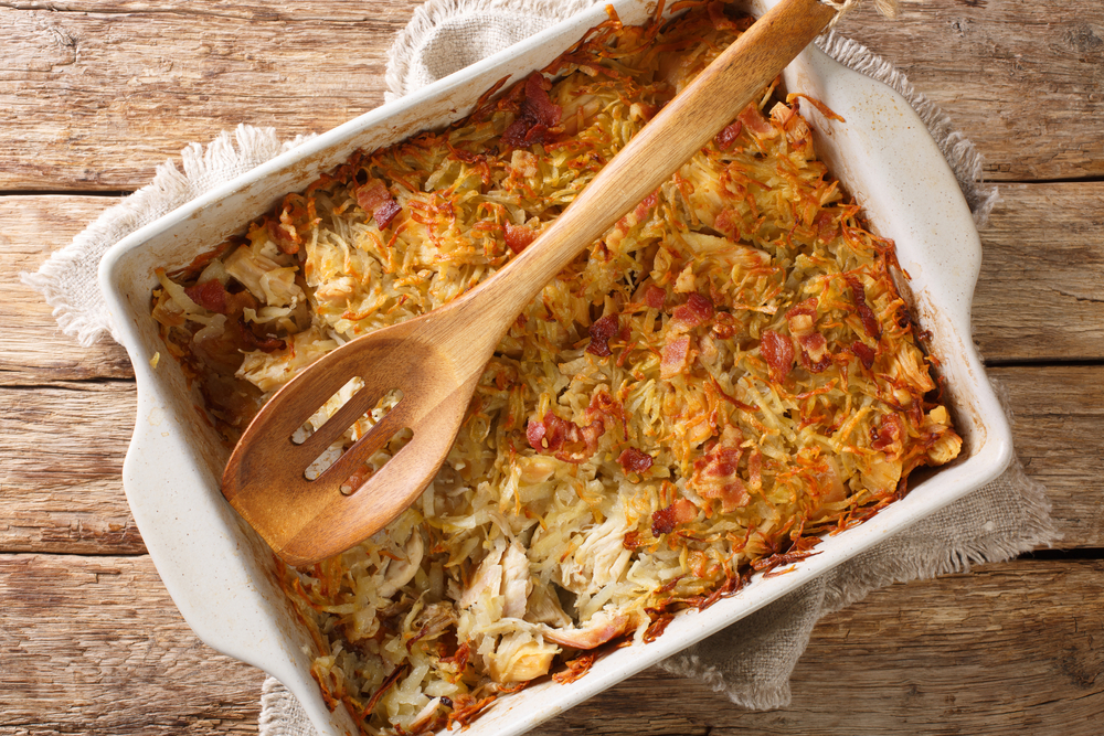 Canadian Rappie Pie, an Acadian classic comfort food dish made with grated potatoes and chicken closeup in a baking dish on the table. Horizontal top view from above
