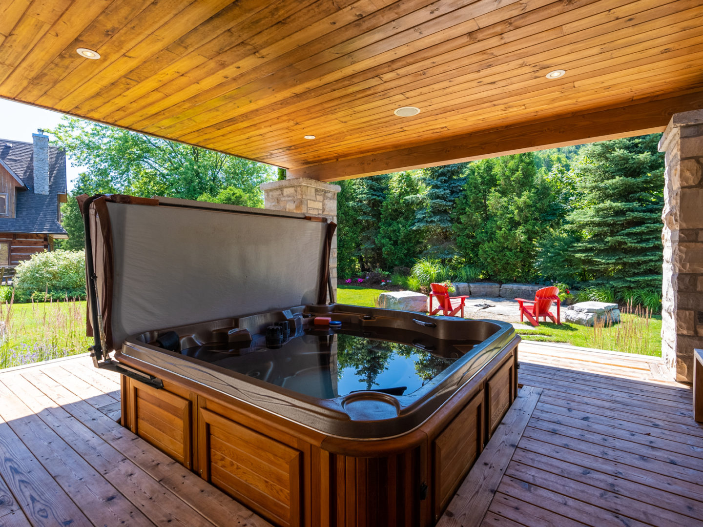 A spacious hot tub sitting on a covered outdoor patio.