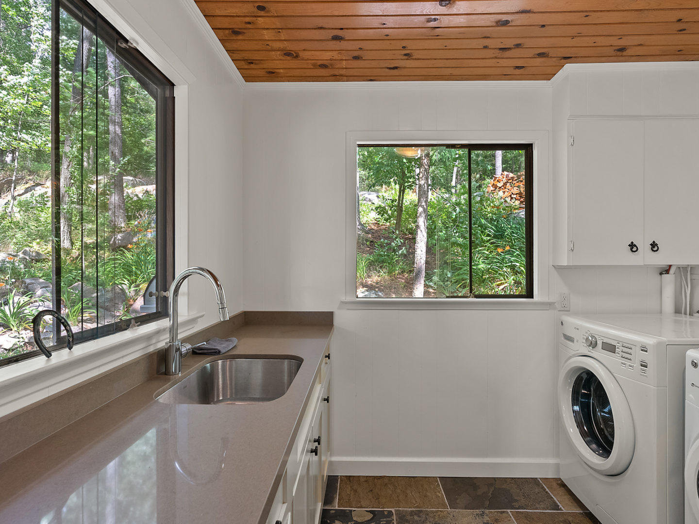 A small laundry area with a sink, a washing machine, and a dryer.