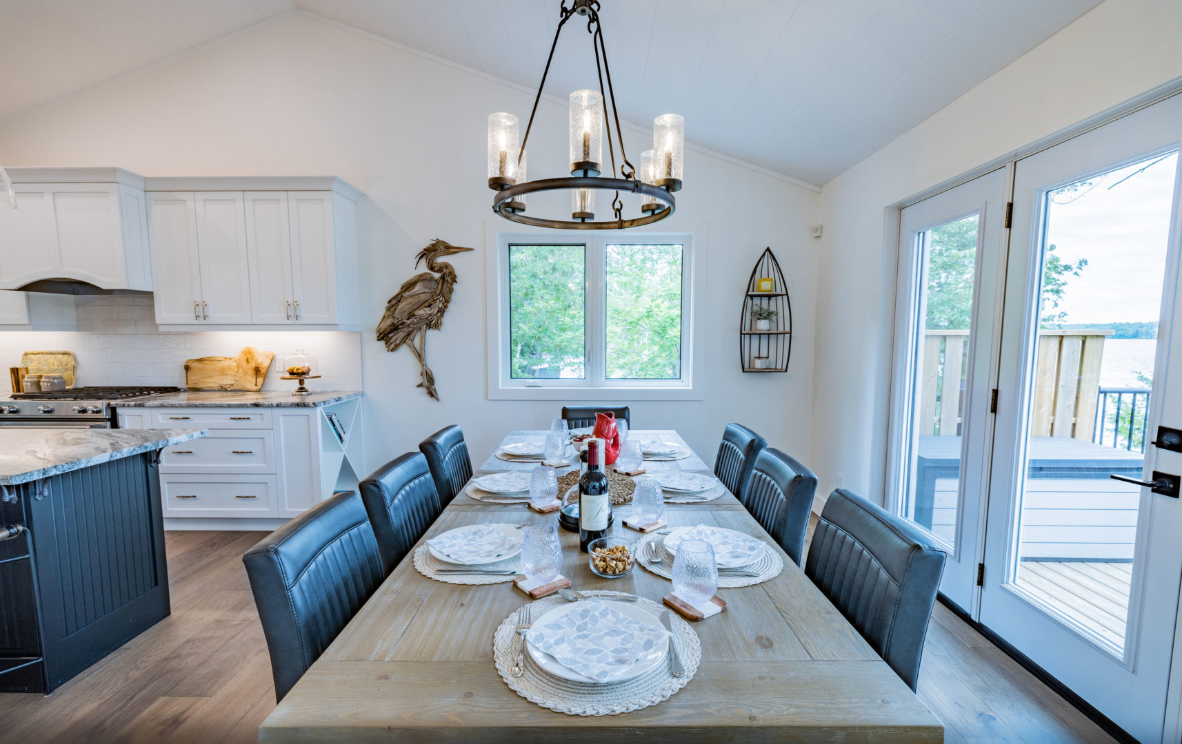 A dining table set with plates, with three chairs on either side.