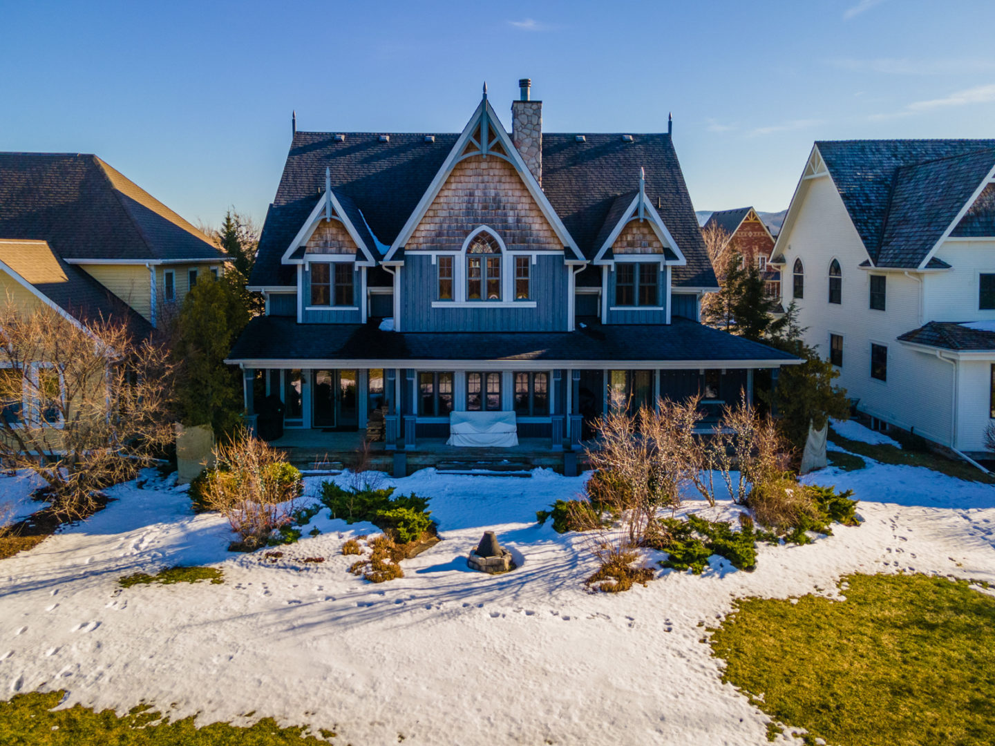 Exterior of the back of a luxury home with a landscaped backyard.