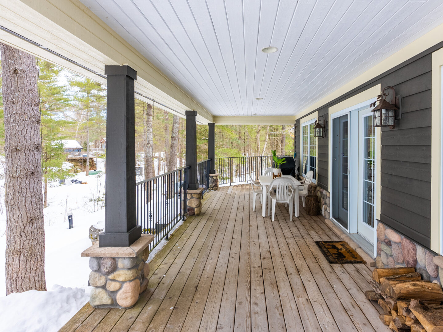 A long back porch spanning the length of a big lakefront home.