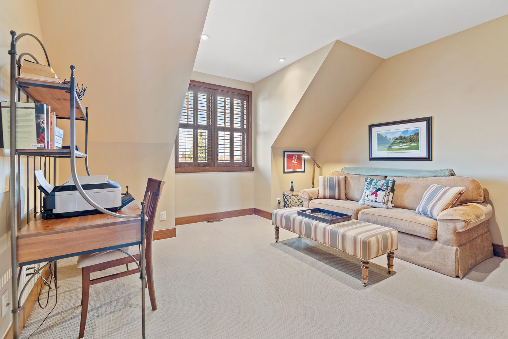 A bright space with a couch, a coffee table, and a small desk.