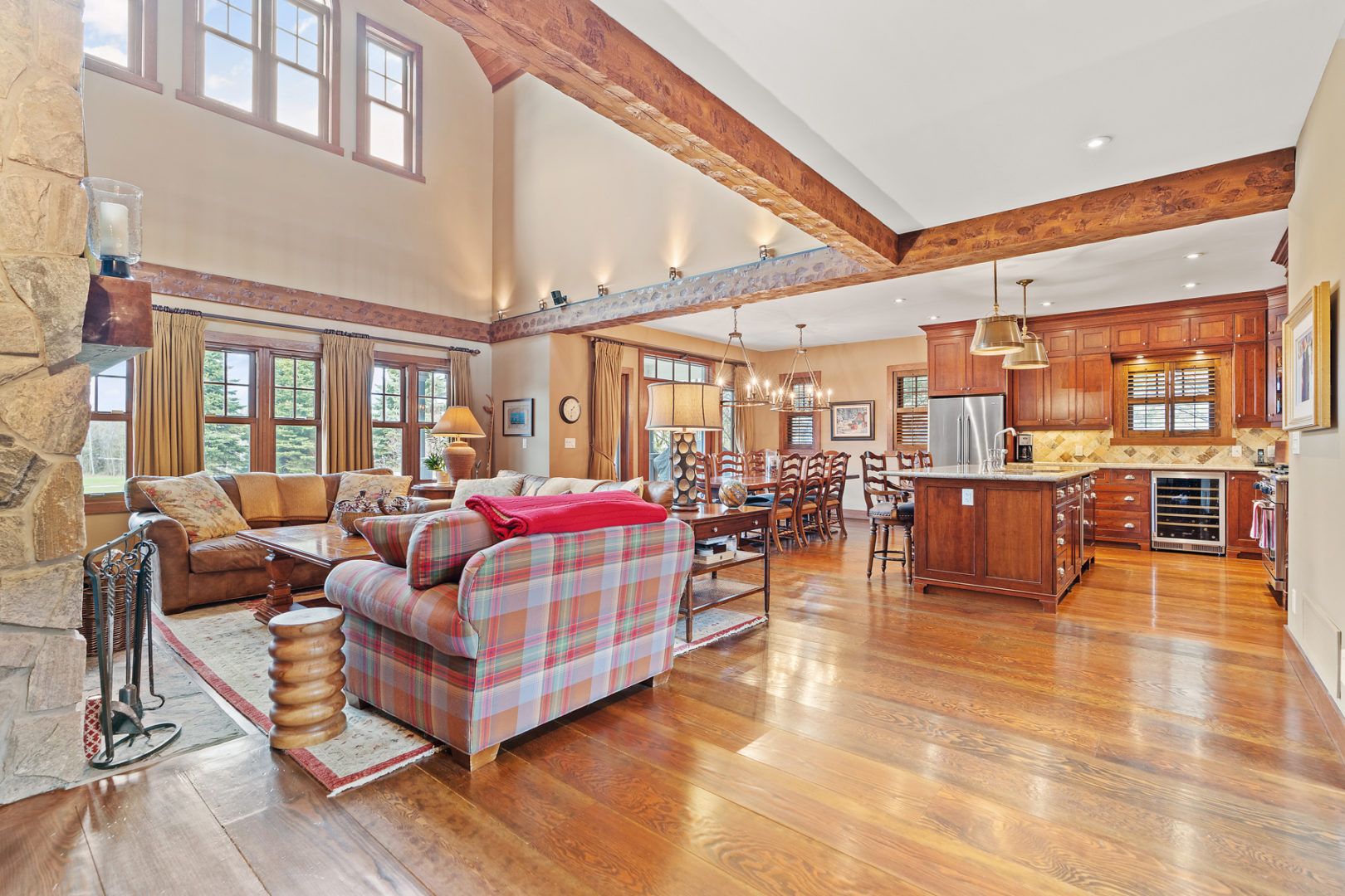 A large open-concept area with a living space, a kitchen and dining area, and high ceilings spanning two floors.