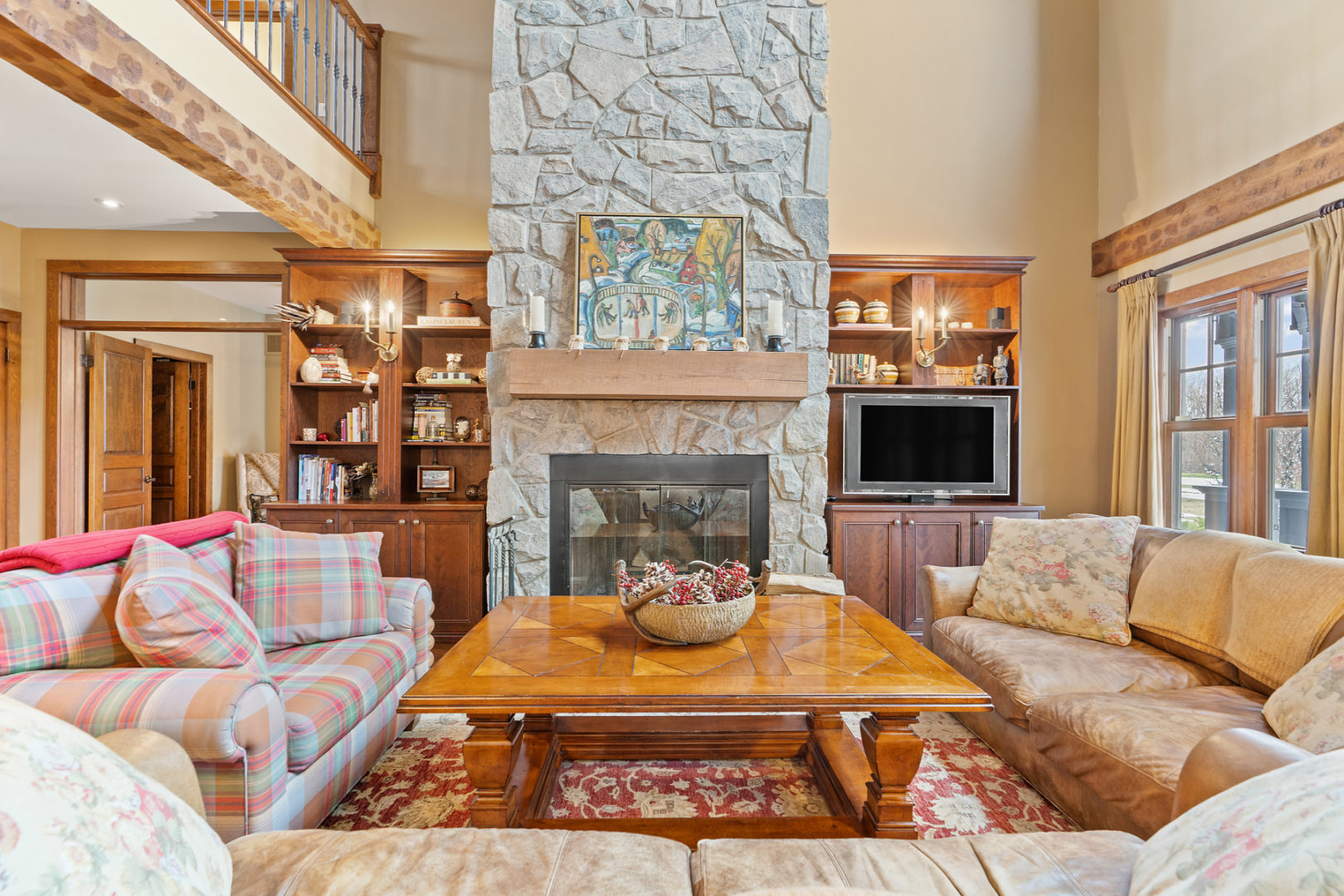 A floor-to-ceiling fireplace is the centrepiece of a bright, cozy chalet living area.
