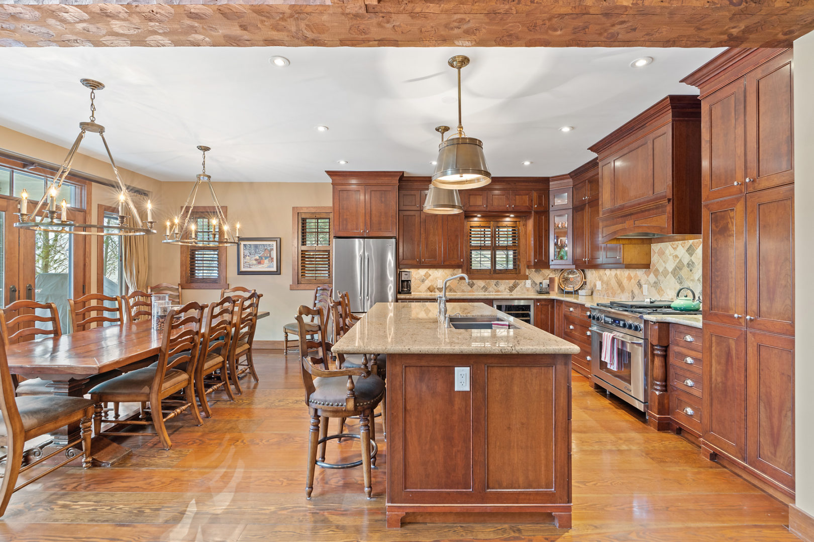 A large open-concept kitchen with warm wood cupboards, a dining area, an island, and modern appliances.