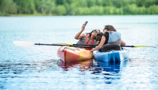 Mother and Daughter Taking Selfie with Dog in Kayaks while on family Vacation