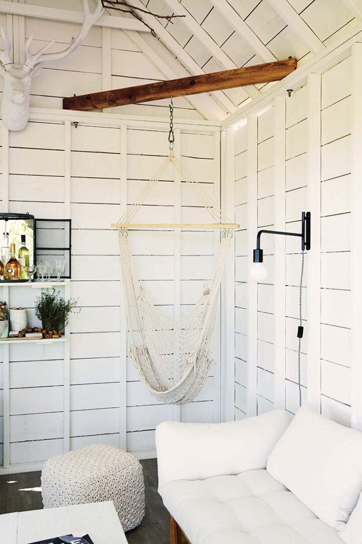 White hammock chair in corner of a white room at the cottage