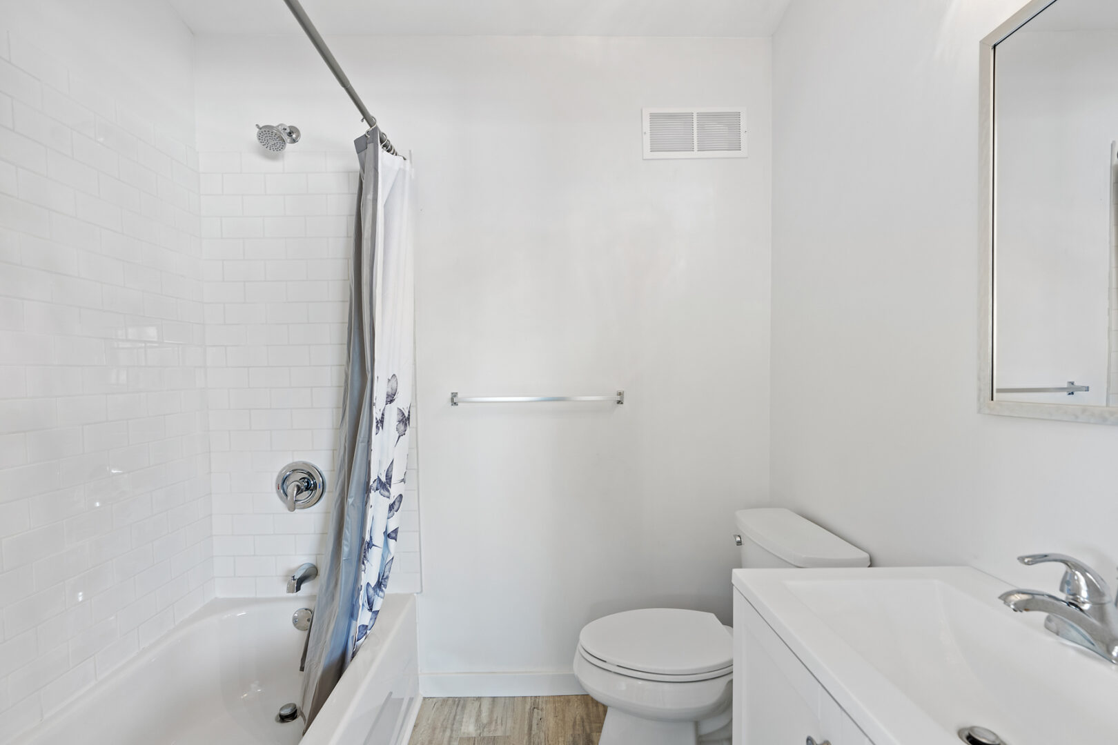 A simple bathroom with a toilet, a sink, and a bathtub/shower combo.