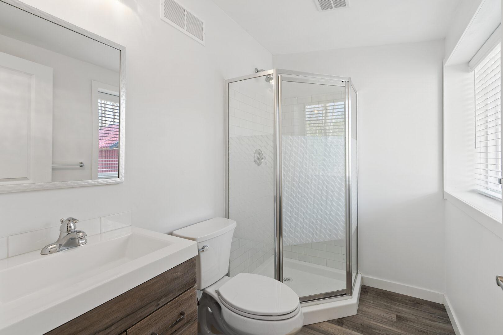 An ensuite bathroom with a toilet, a sink, and a walk-in shower.