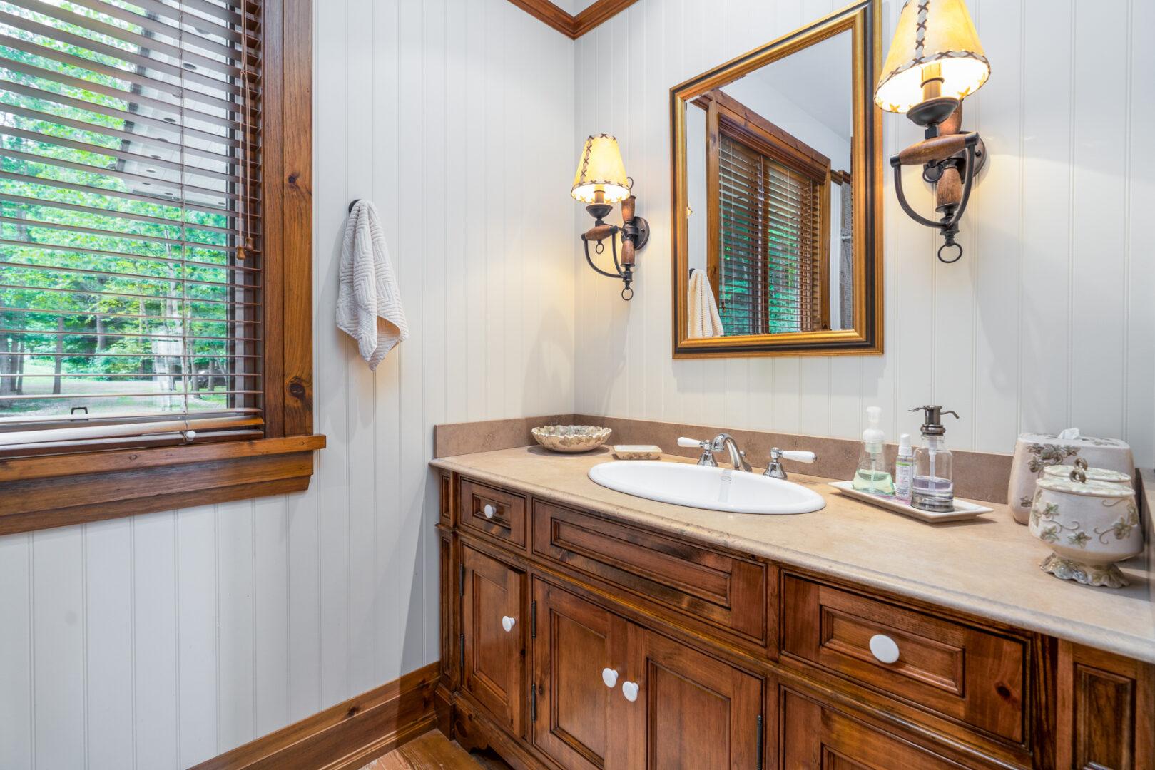 A simple bathroom sink with wooden cupboards underneath.