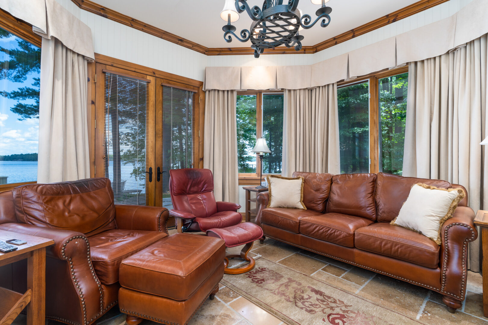 A small sitting room with leather couches and large windows.