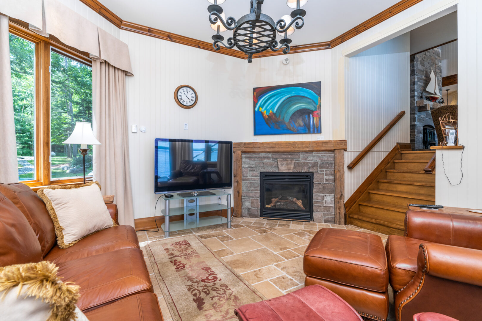 A small sitting area with leather couches and a stone fireplace.