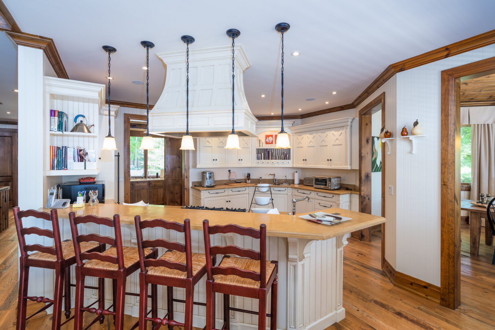 A bright kitchen with white cabinets and an island with barstools.