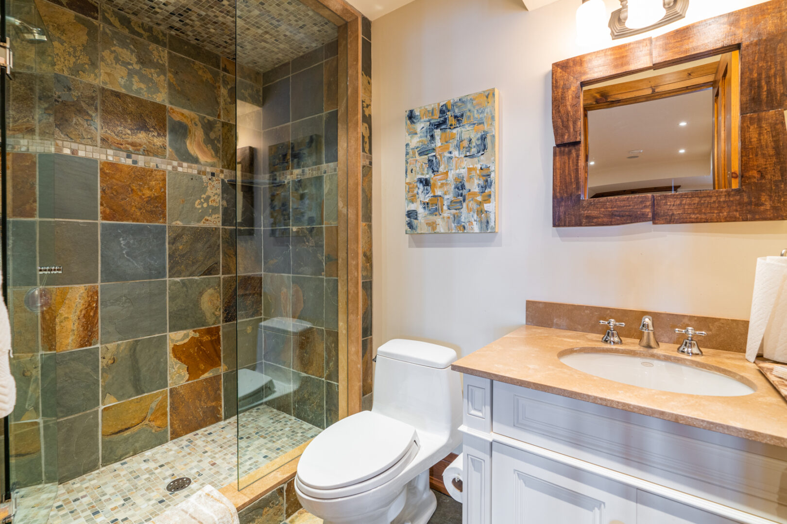 A small bathroom with a toilet, a sink, and a walk-in shower.