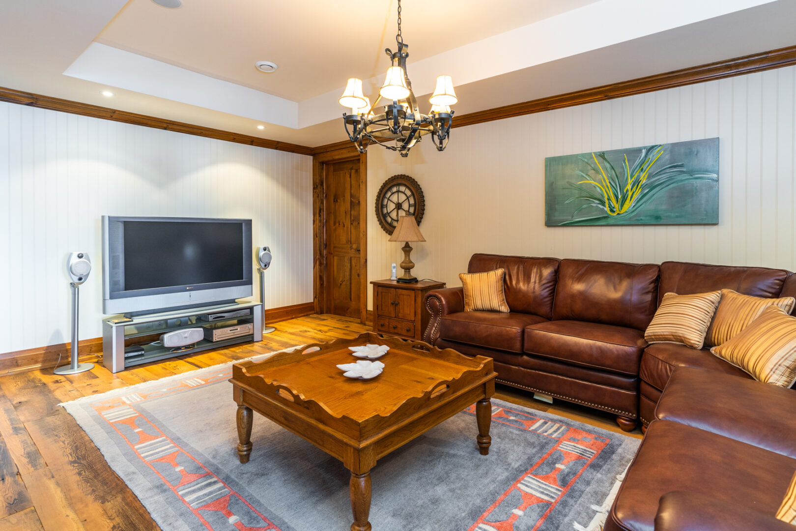 A large lower-level living space with couches, a coffee table, and a television.