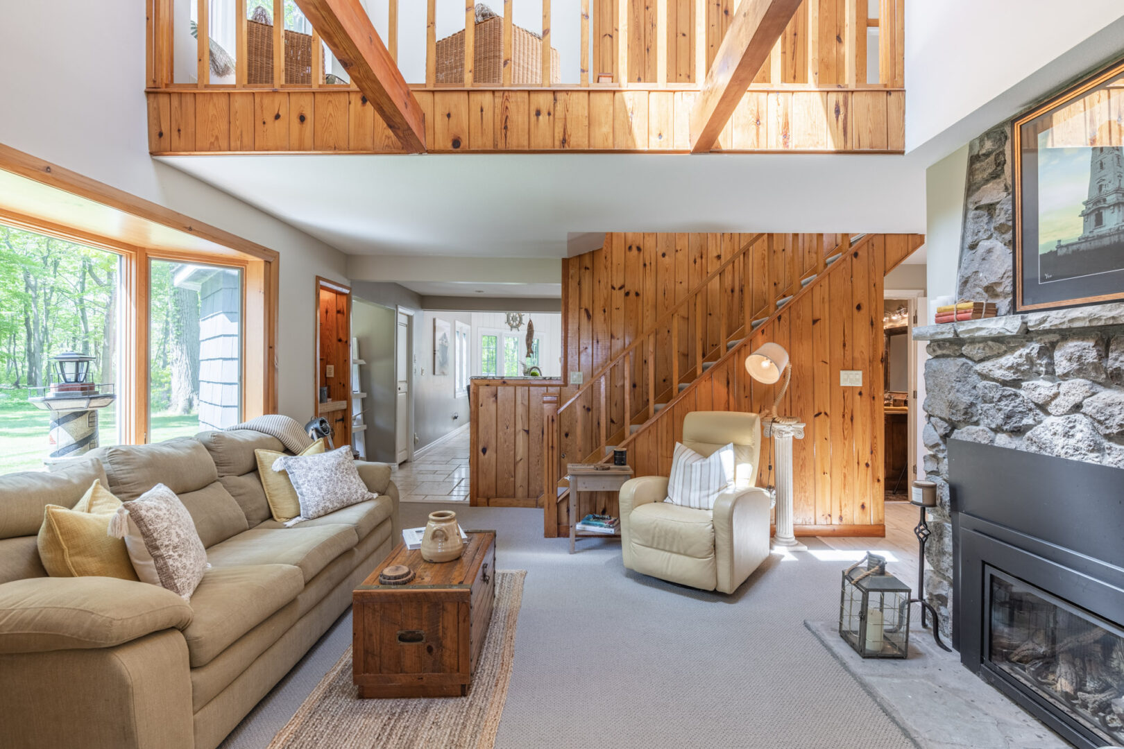 A cozy but bright cottage living area with a couch, a chair, and a gas fireplace.