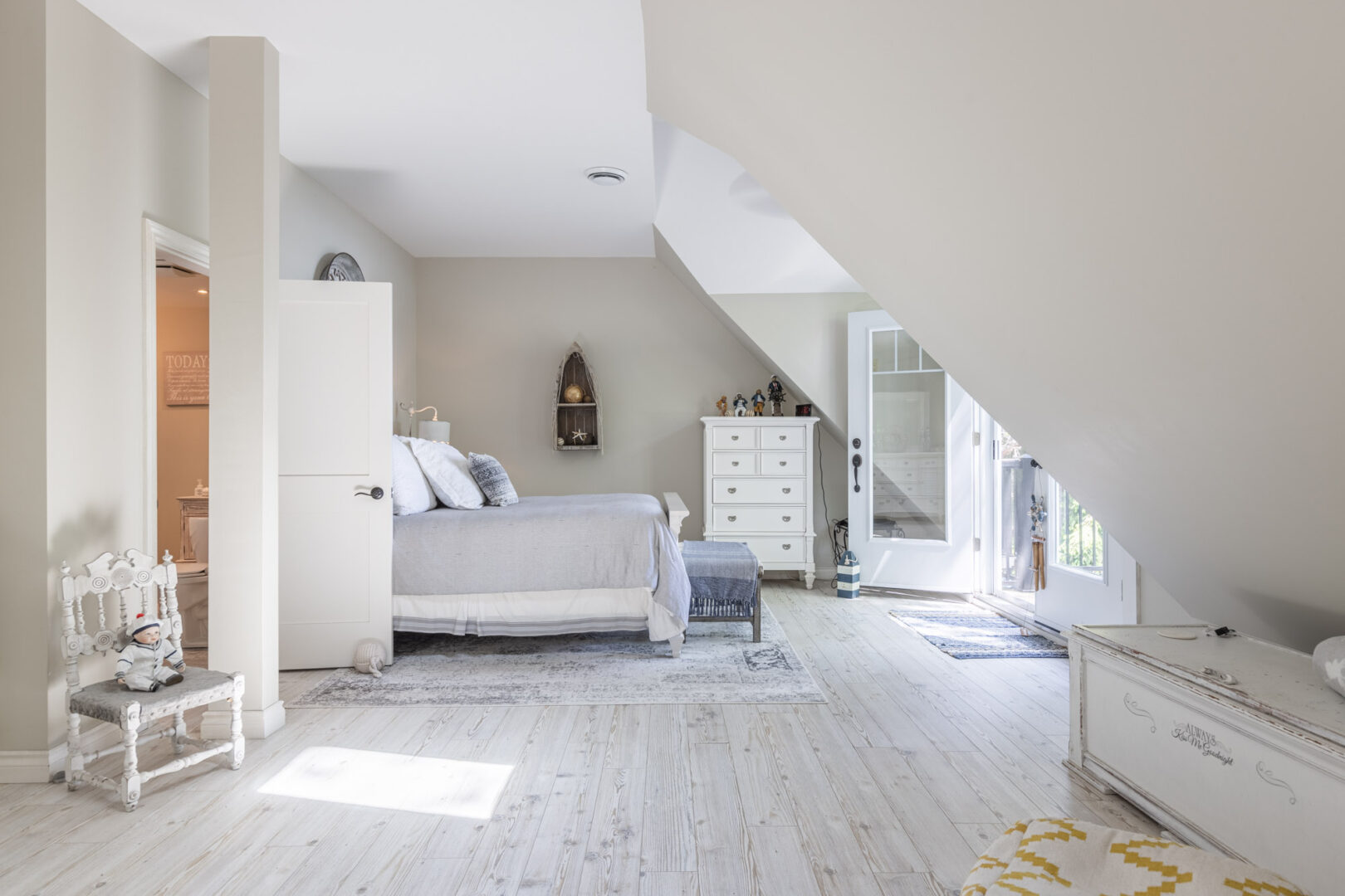 A large, bright primary bedroom with ample floor space, a large bed, and lots of natural light.