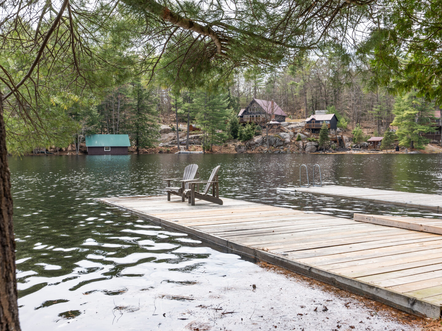 A long wooden dock stretches into a calm lake.