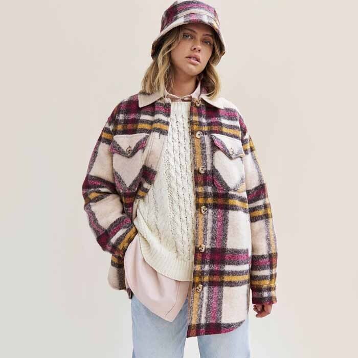 Woman wearing pink and white Roots plaid shacket