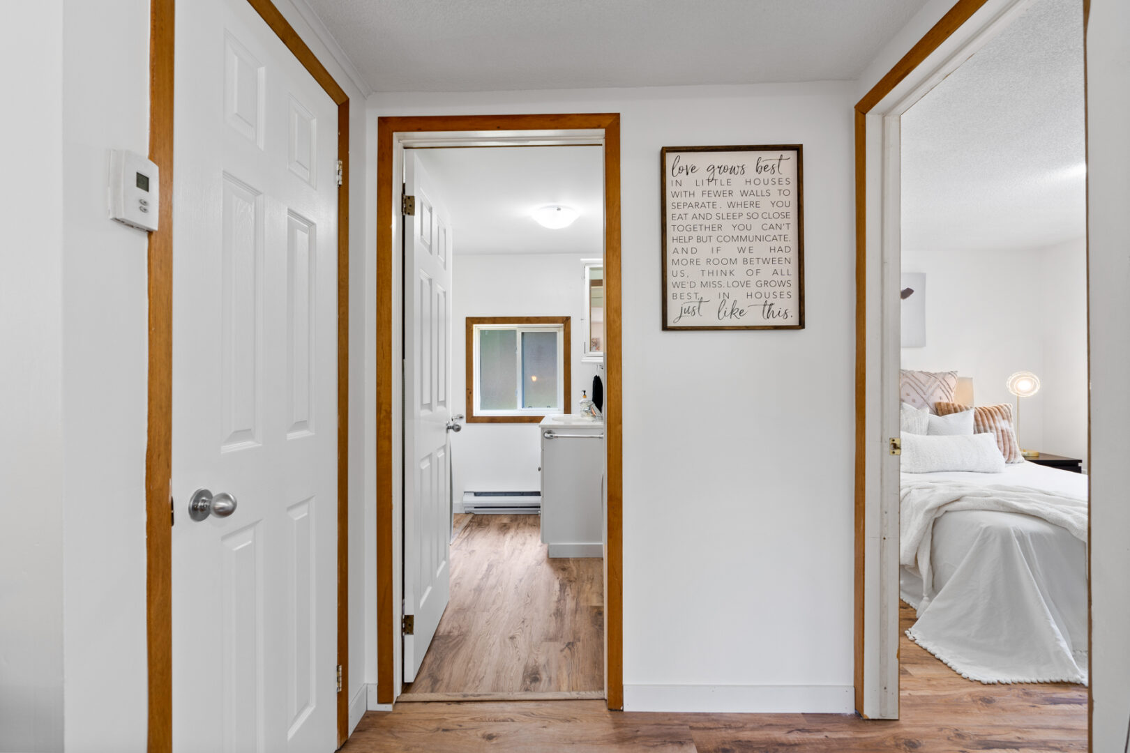 A small hallway with doors leading to a washroom area and a bedroom.