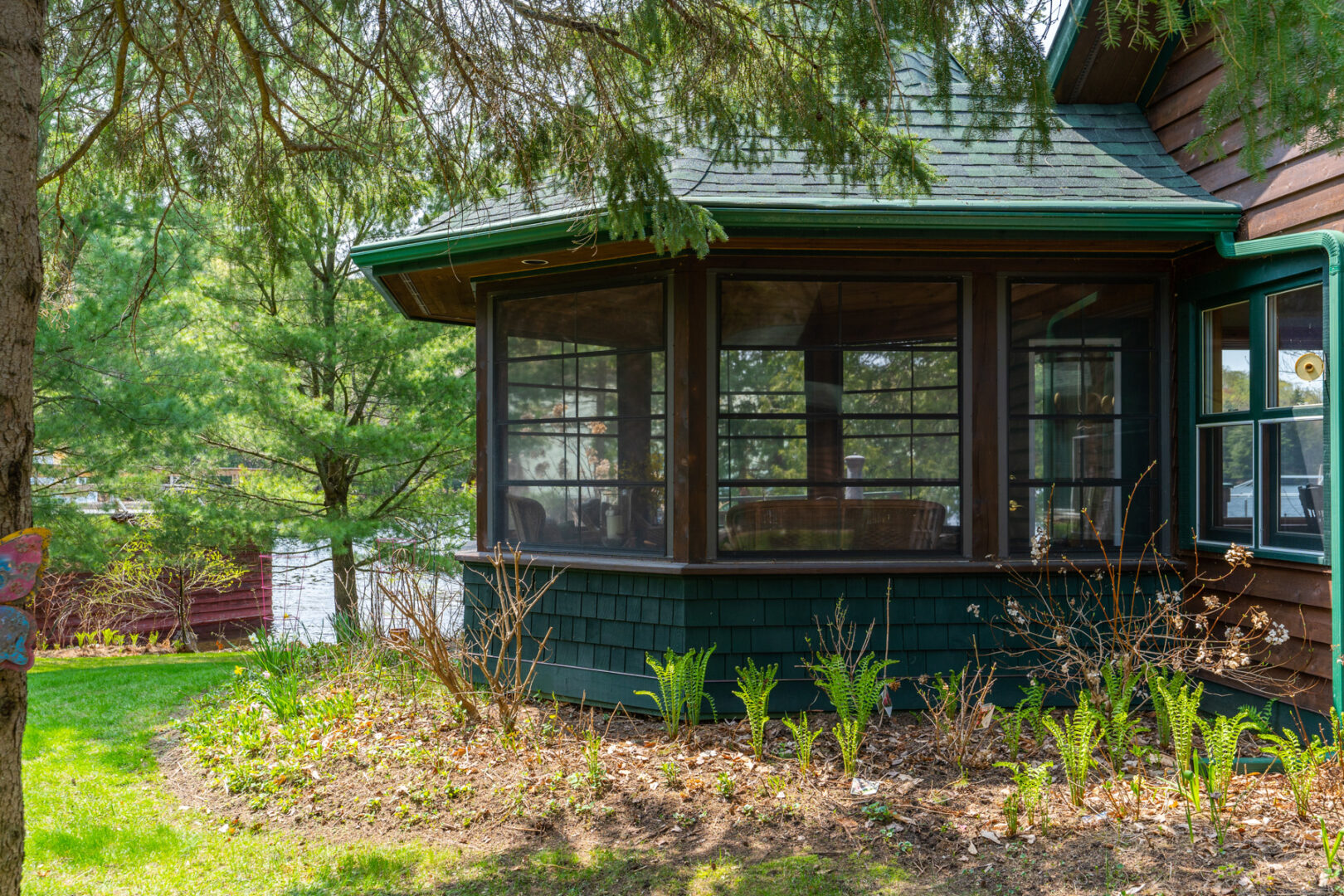Exterior view of an octagonal screened-in room that has a green room.