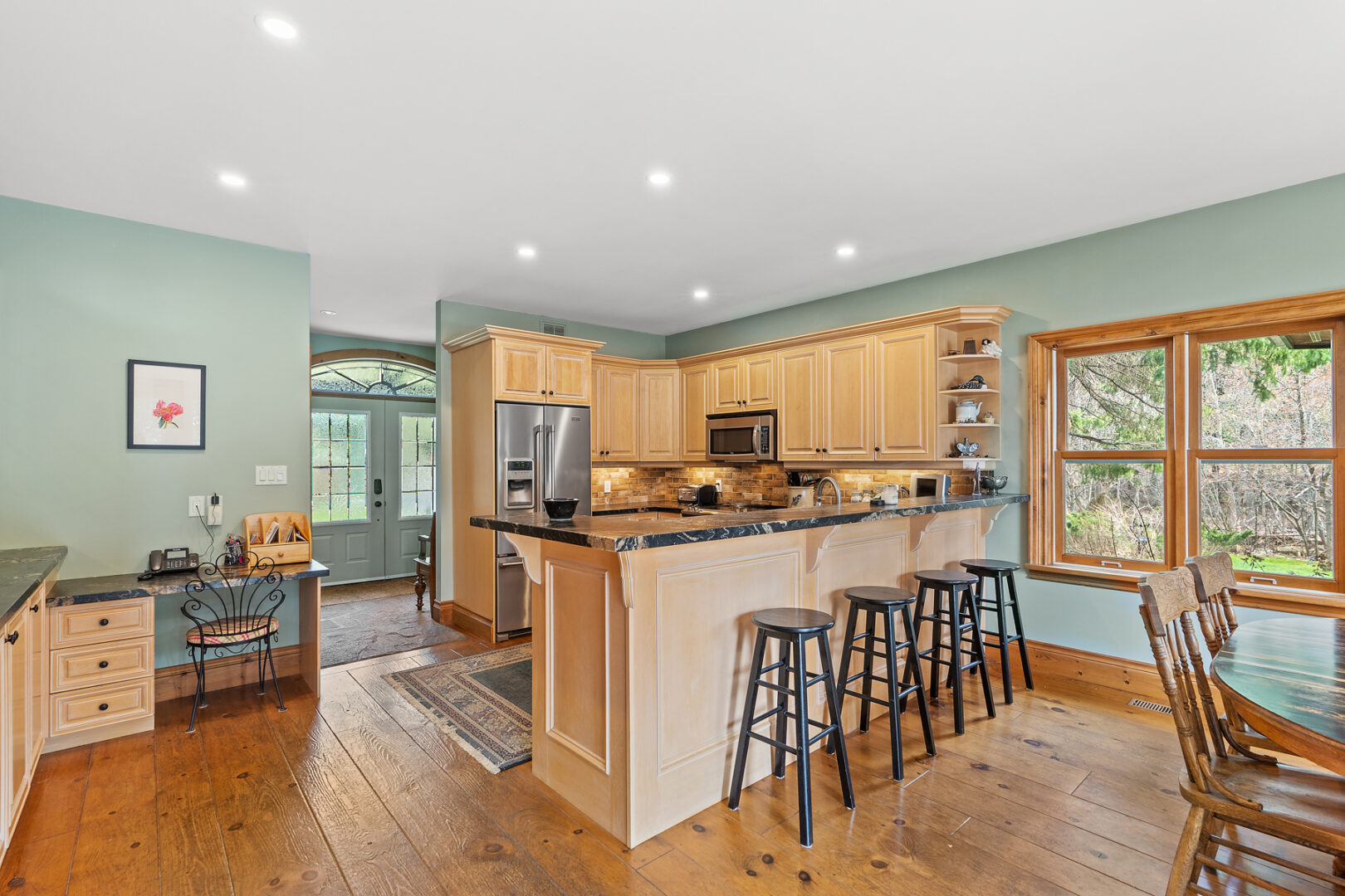 An open space with a kitchen peninsula that provides lots of counter space and barstool seating.