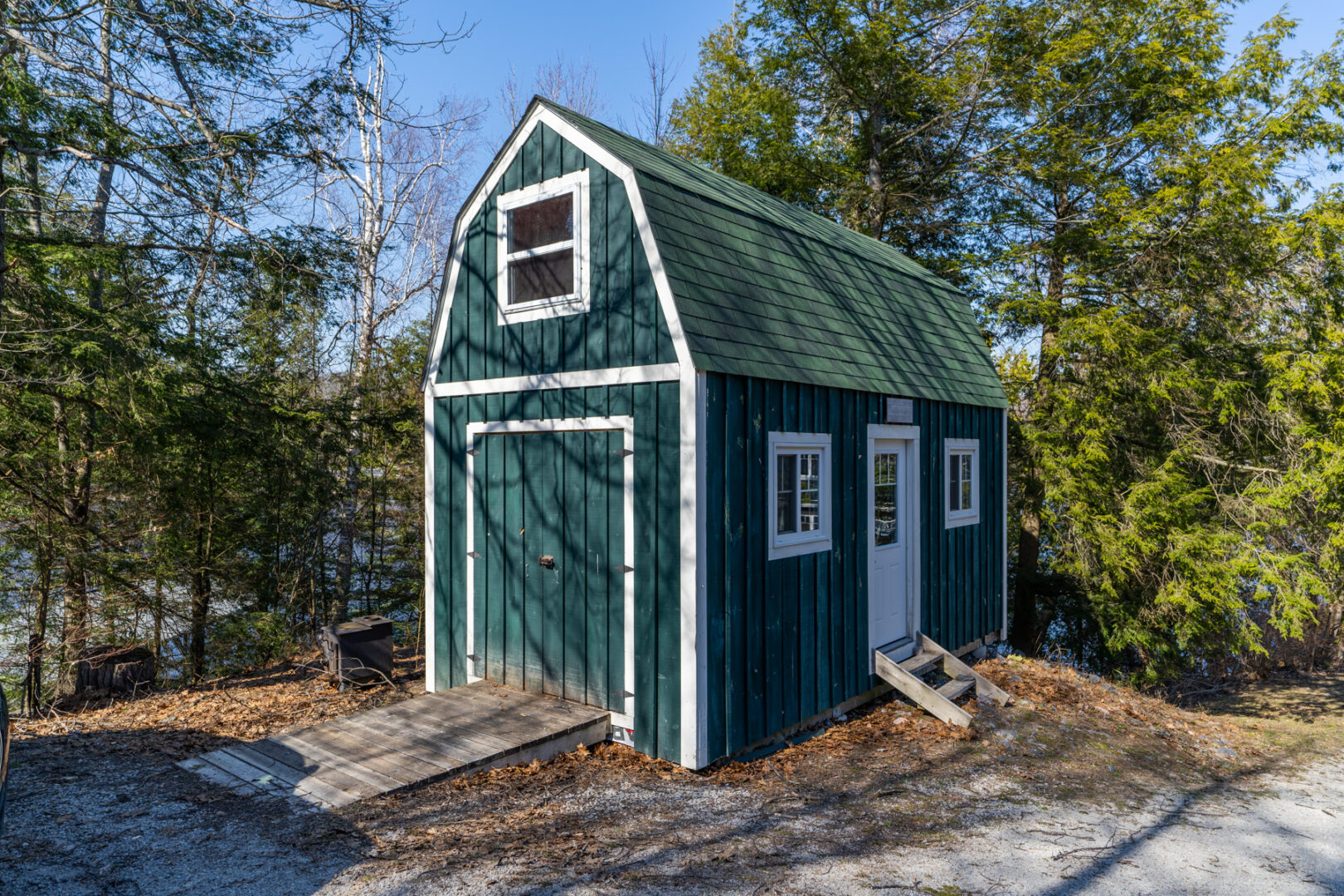 Exterior of a small green bunkie.
