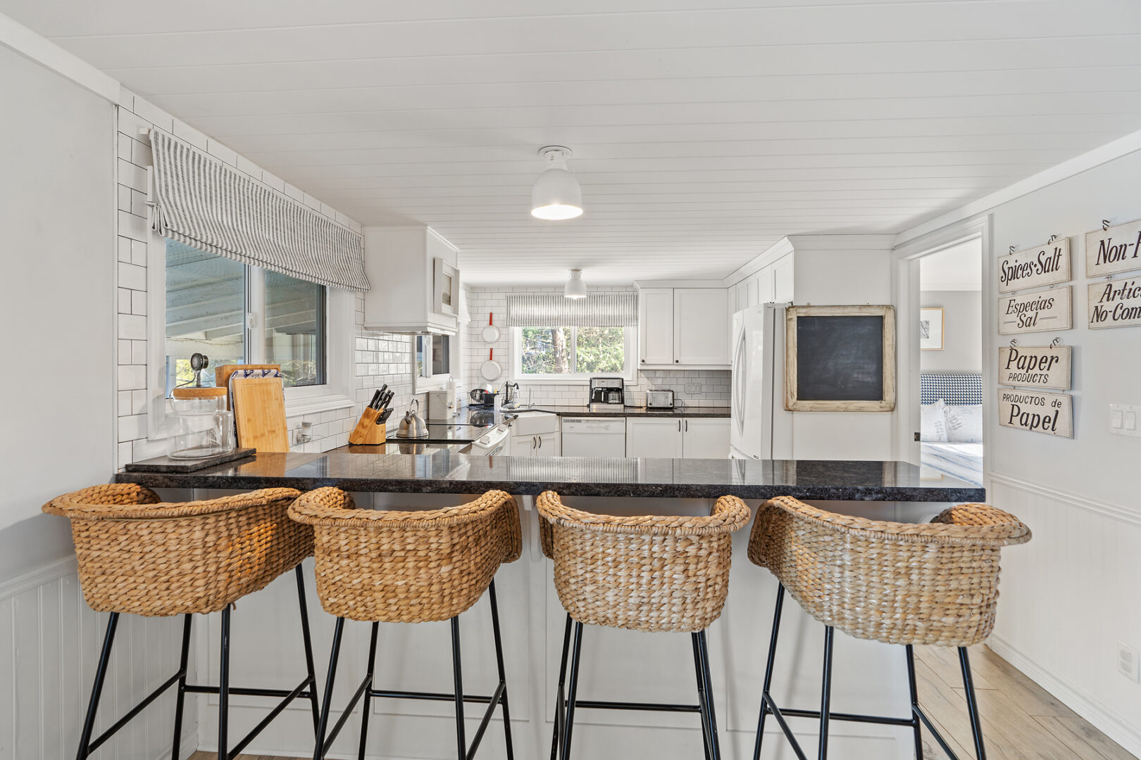 Four barstool chairs sit in front of a kitchen peninsula.