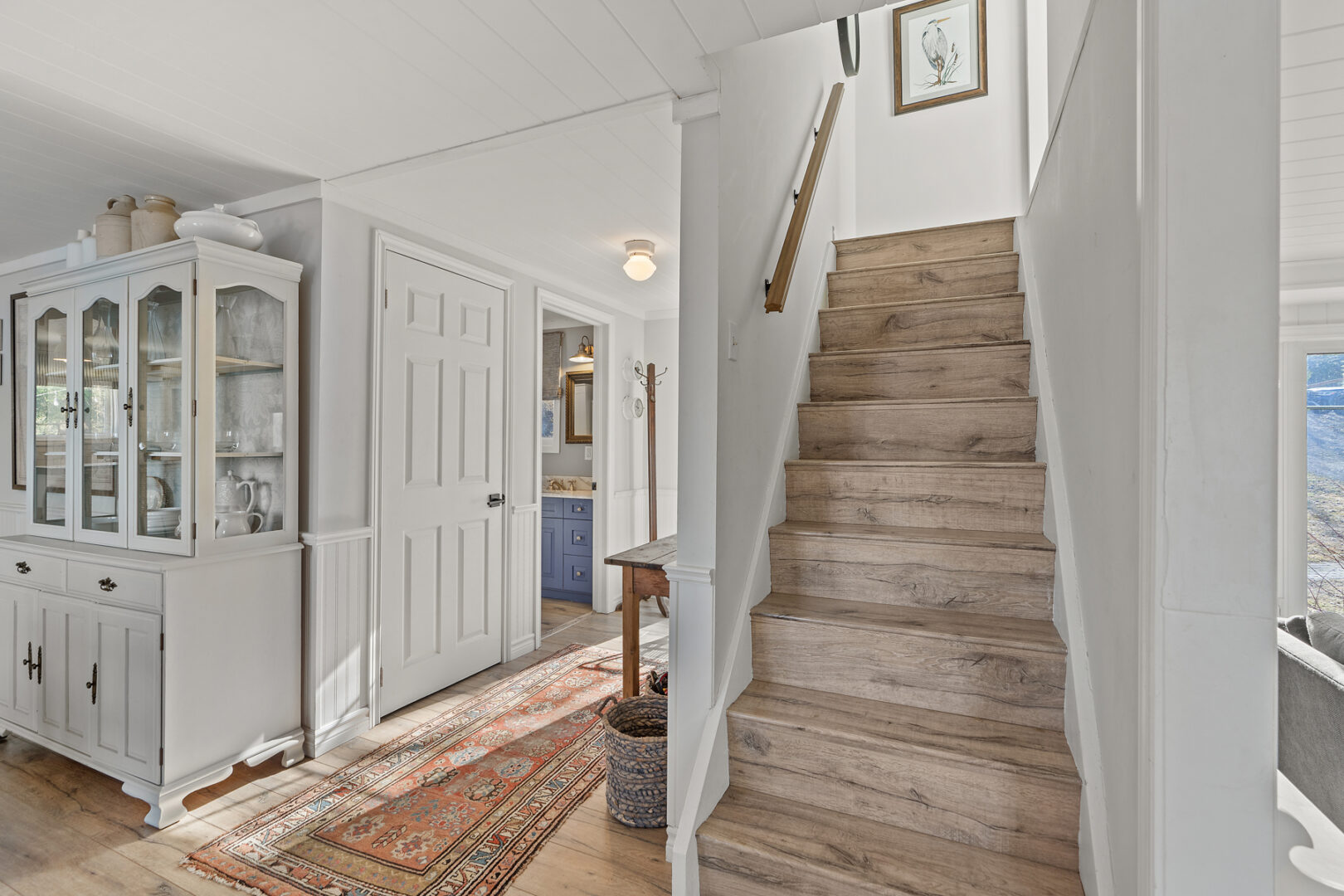 A staircase leads up to the second level of a cottage.