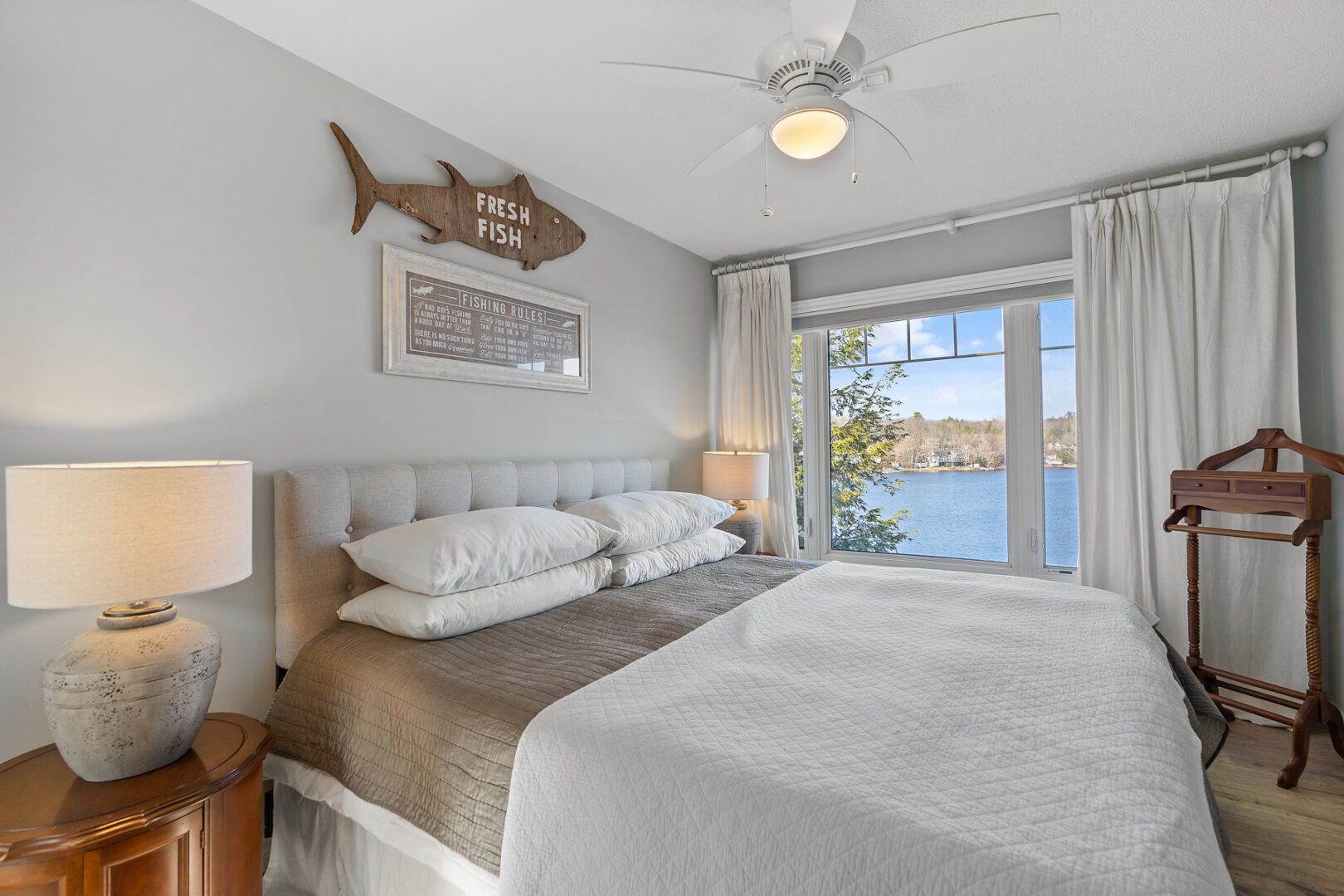 A bright bedroom with large windows and neutral decor.