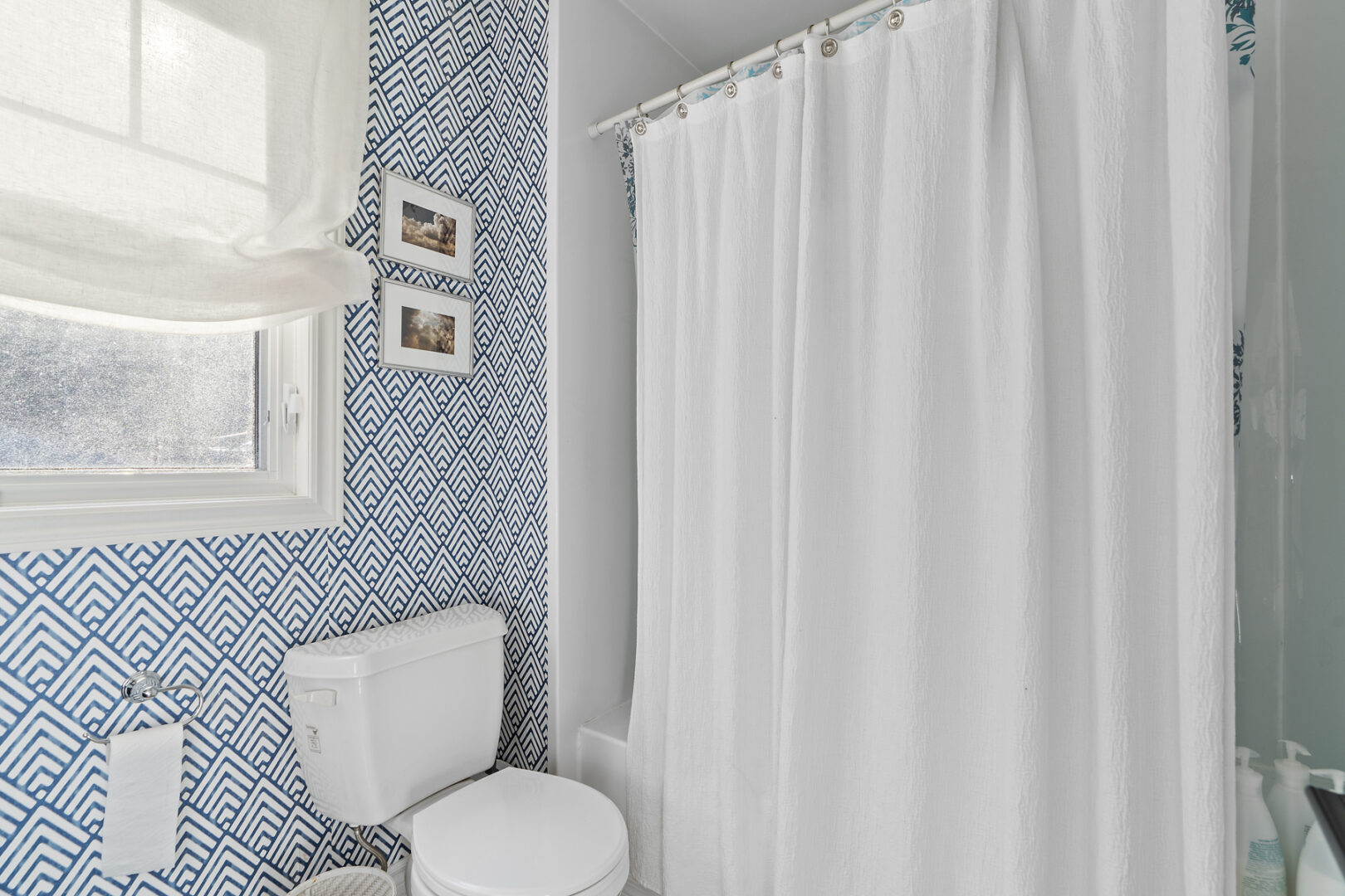 A bathroom with a toilet and a shower-tub combo.
