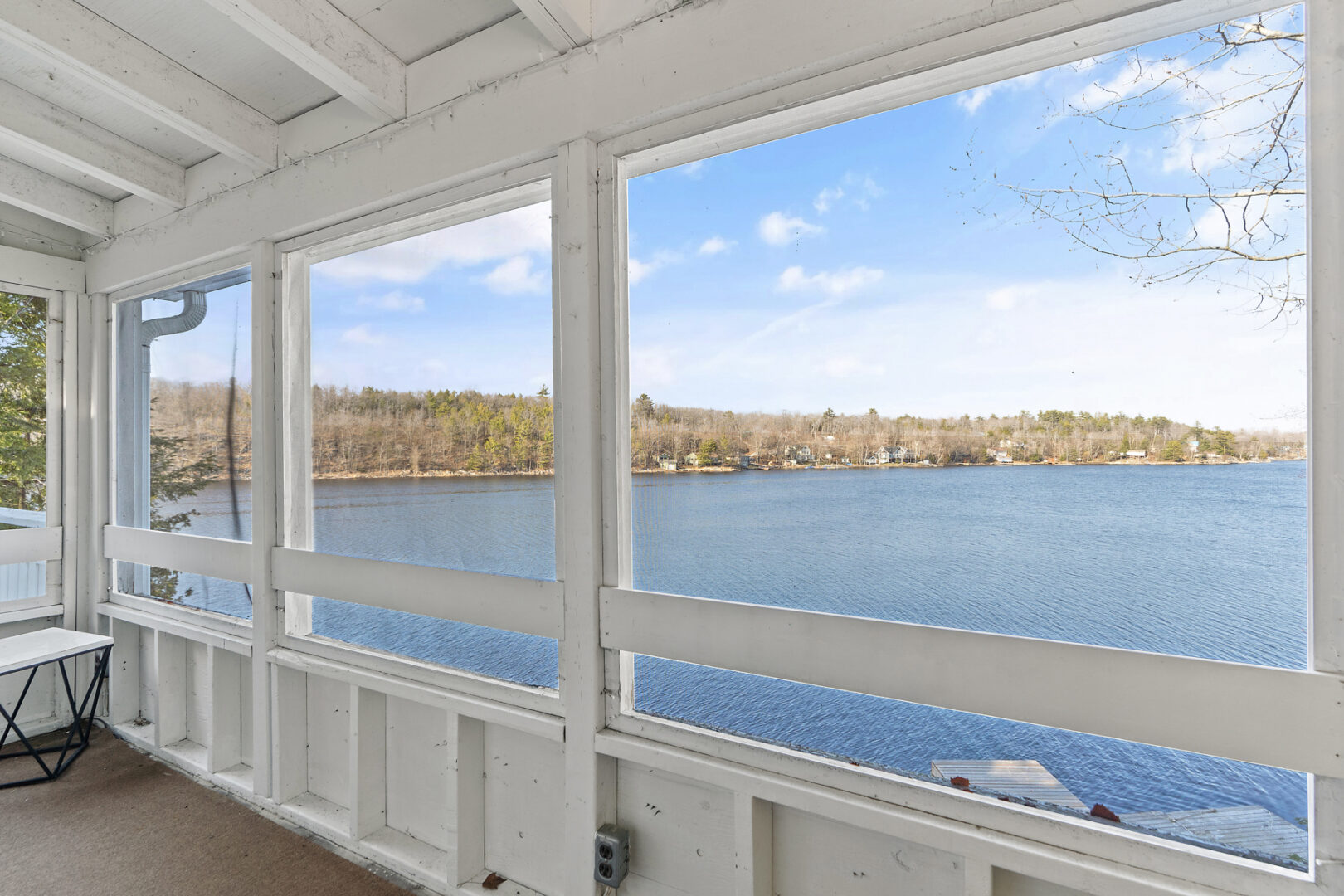 A screened-in porch area overlooking a lake.