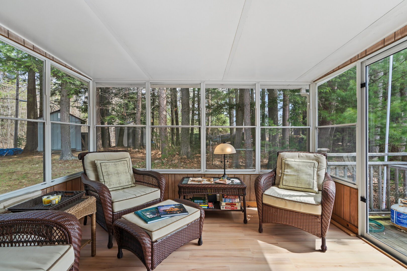 A bright sunroom with seating and large windows all around.