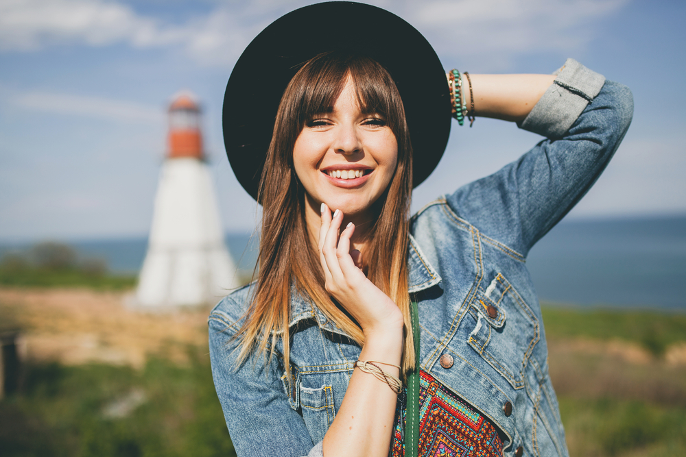 girl wearing hat and denim jacket in the sun