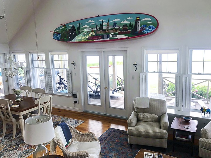 Paddleboard with a painted mural of Canada hangs in a P.E.I living room