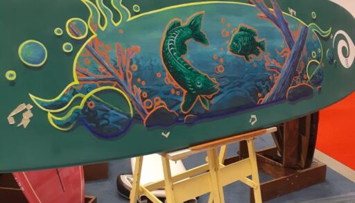 paddleboard with green fish painted on