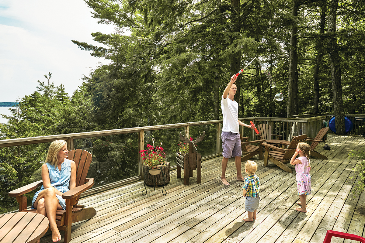 Rebecca, Cam and their daughter play on the cottage deck