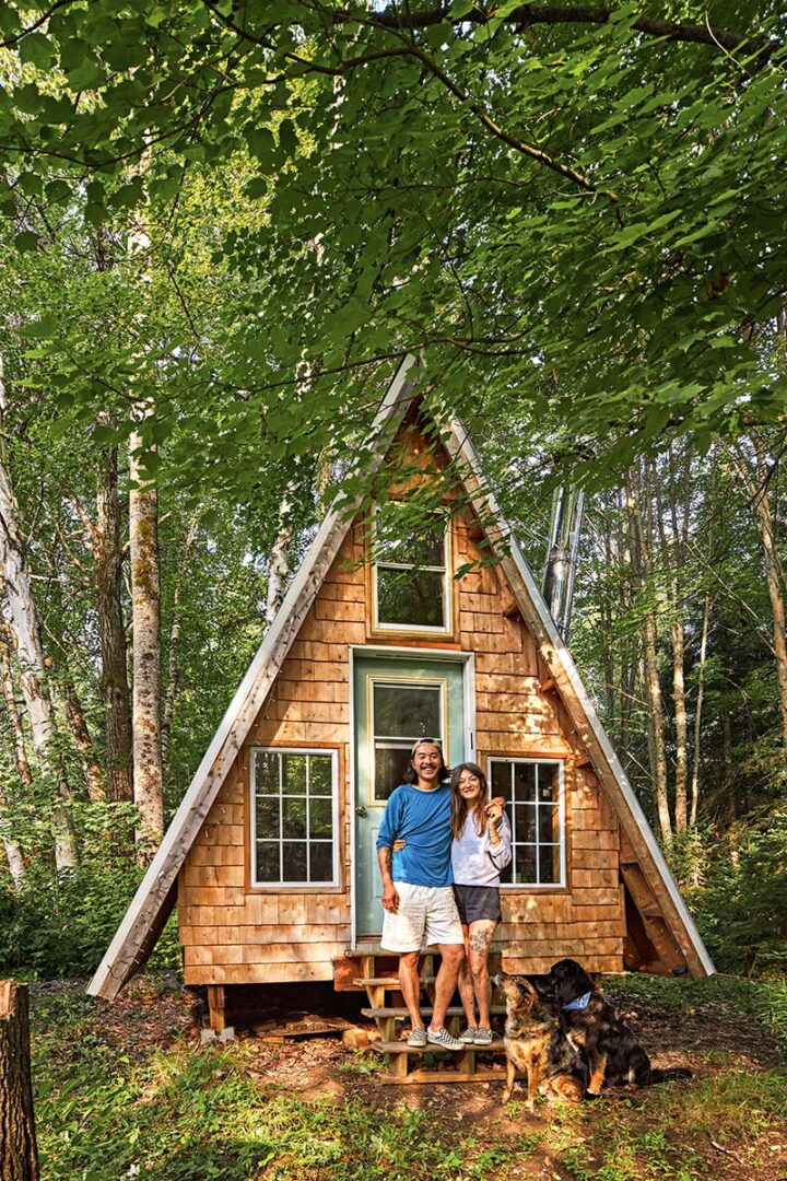 Andrew and Amber with the dogs stand in front of their A-frame