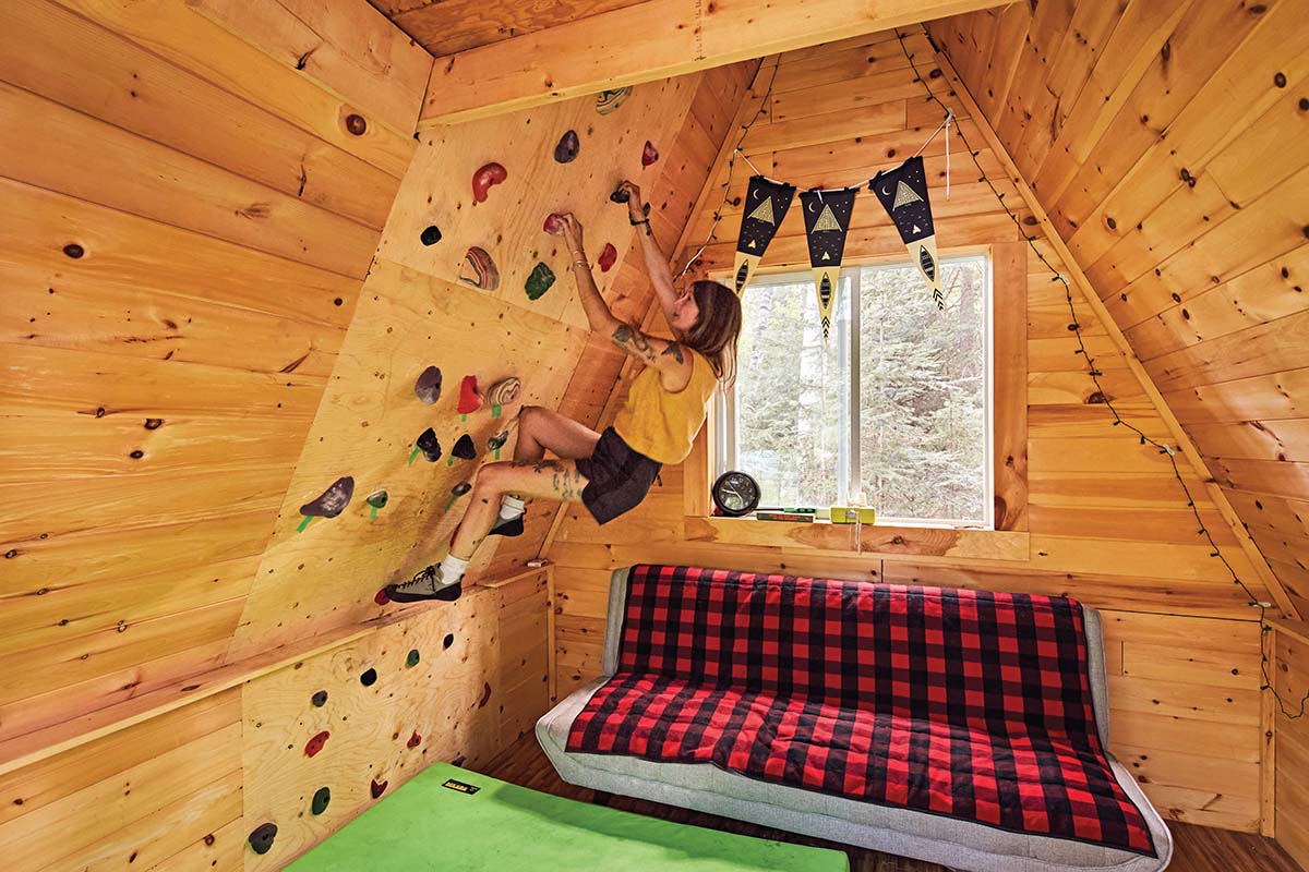 Amber scales the climbing wall inside the couples' A-frame