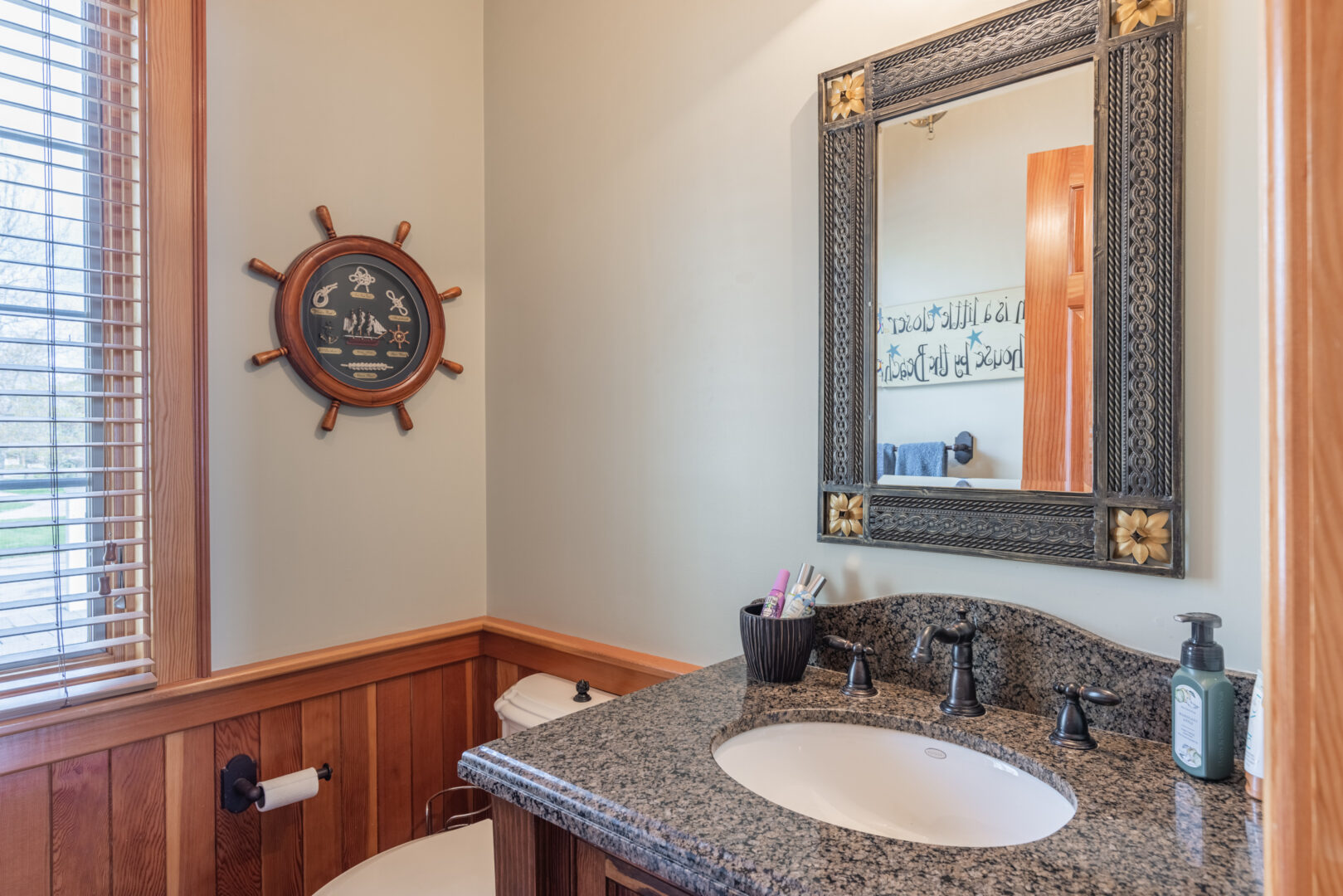 A small bathroom with a toilet, a sink, and a mirror.