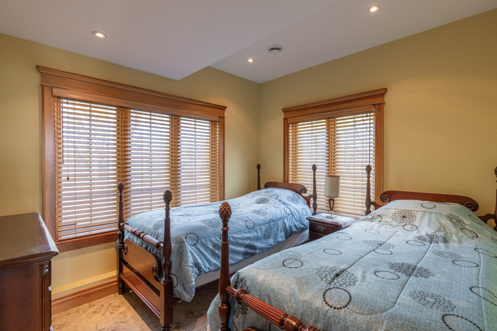 A big bedroom with two beds and large windows.