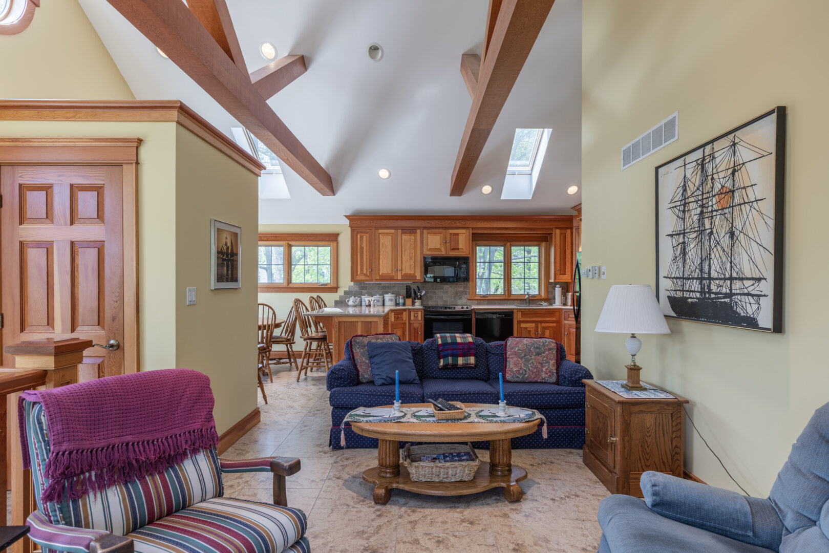 Interior of a big guest house on a lake property. A living area flows open-concept style into a kitchen.