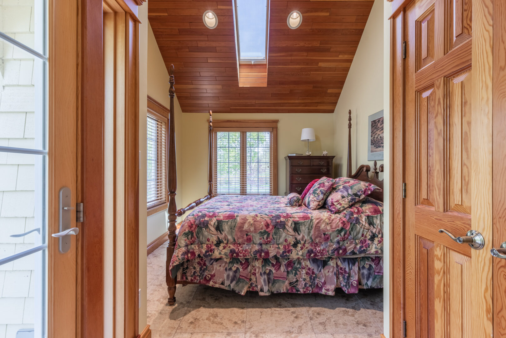 A big bedroom with a large bed and a skylight.