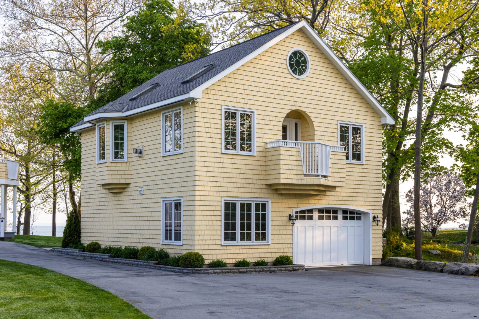 Exterior of a big guest house with yellow siding and a white garage.
