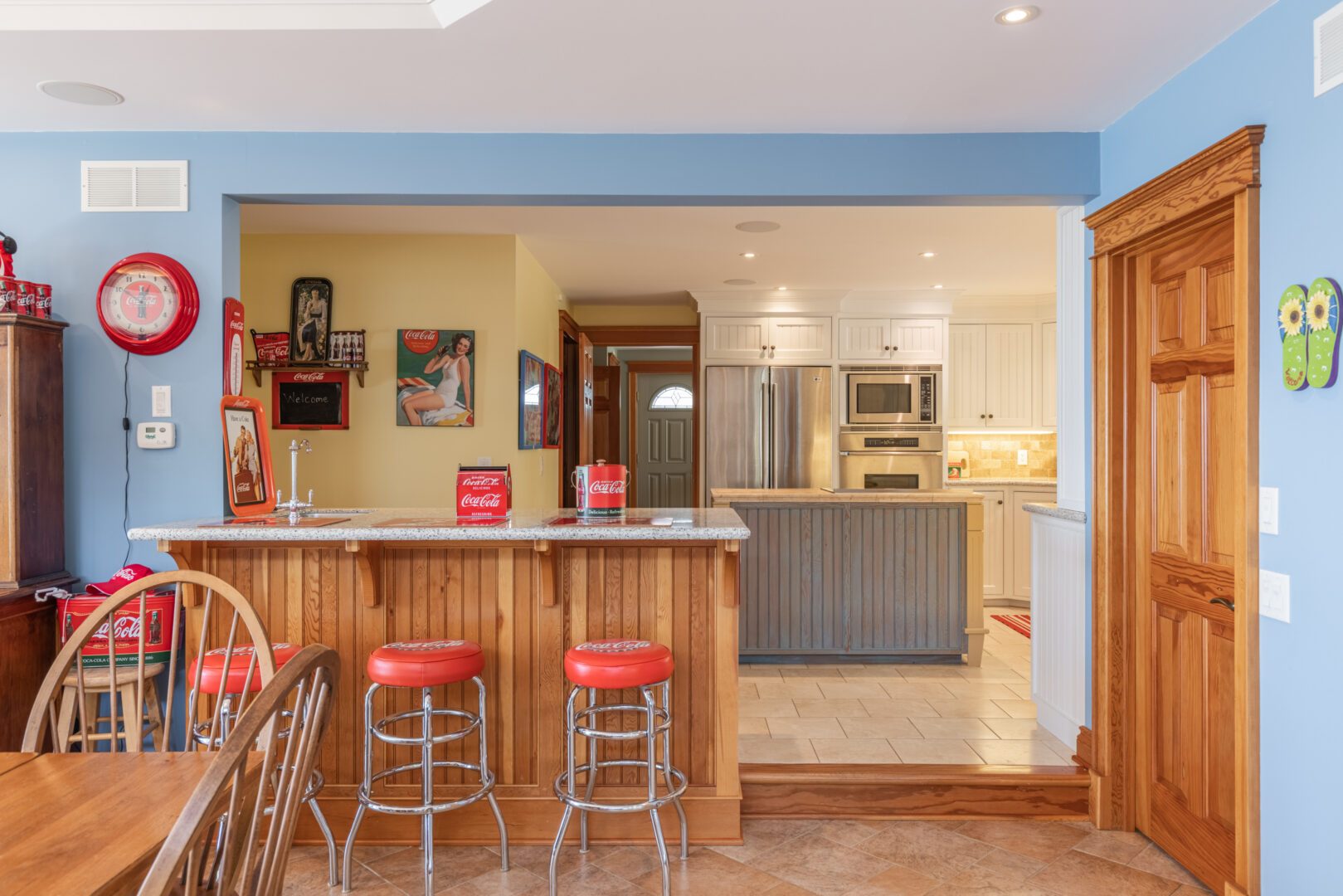 View into a lake house kitchen, with barstool seating in front of the kitchen area.